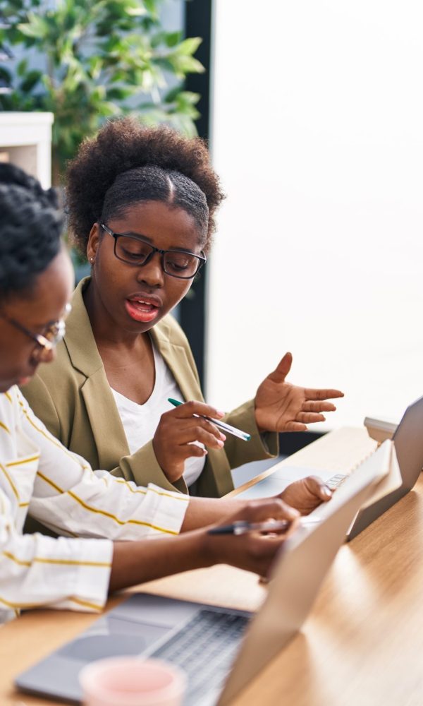 African american friends business workers sitting on table working at office